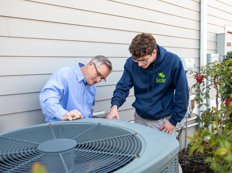 Technician discussing AC installation and replacement